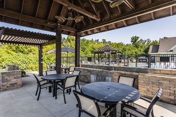 An outdoor patio with tables and chairs and a pool